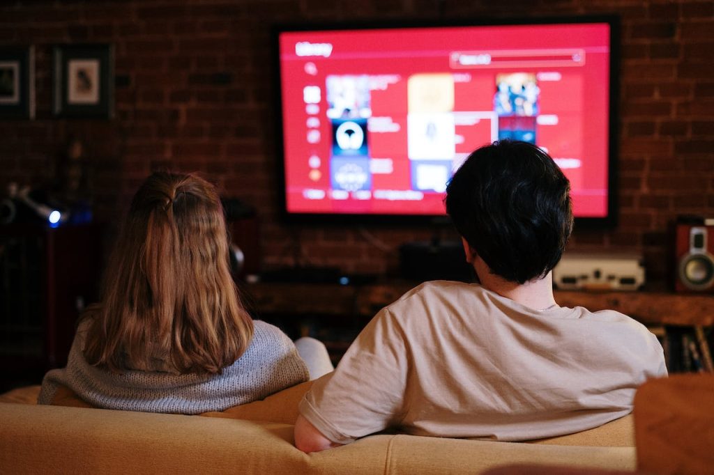 couple sitting on couch watching smart tv